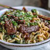 Steaming silky rice noodles mingle with tender beef and crisp vegetables for a hearty, comforting skillet meal.