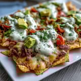 Soccer Game Day Nachos with Cheese Sauce piled high with fresh tomatoes, jalapeños, and cilantro for a festive crowd-pleaser.