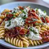 Colorful Caprese pasta with silky burrata cheese, bursting cherry tomatoes, and aromatic basil leaves.  