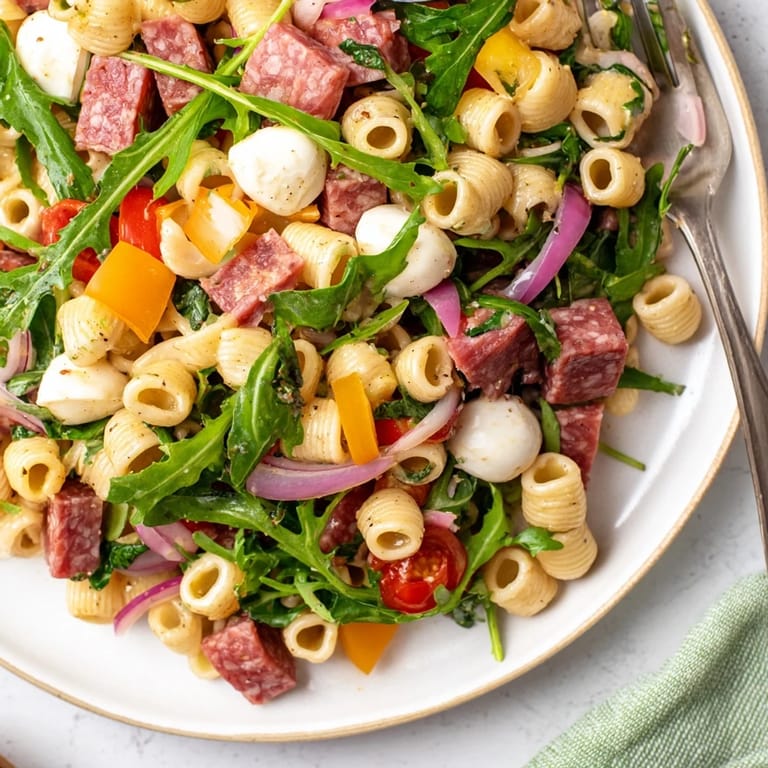Close-up of Spring Antipasto Pasta Salad featuring chopped salami, creamy mozzarella, and tangy pickled vegetables for a refreshing Italian-American bite.
