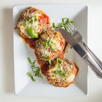 Golden, crispy breaded eggplant slices layered with rich tomato sauce and melted mozzarella for classic Eggplant Parmesan.